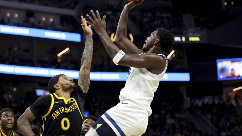 Minnesota Timberwolves guard Anthony Edwards, right, shoots against Golden State Warriors guard...
