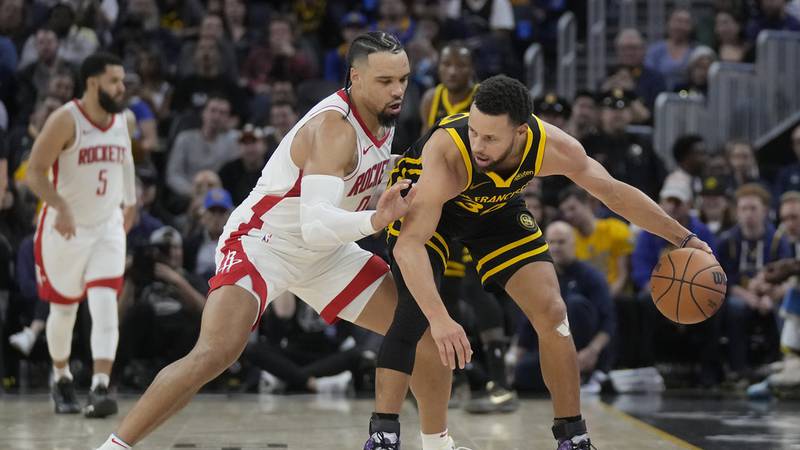 Golden State Warriors guard Stephen Curry, right, is defended by Houston Rockets forward Dillon...